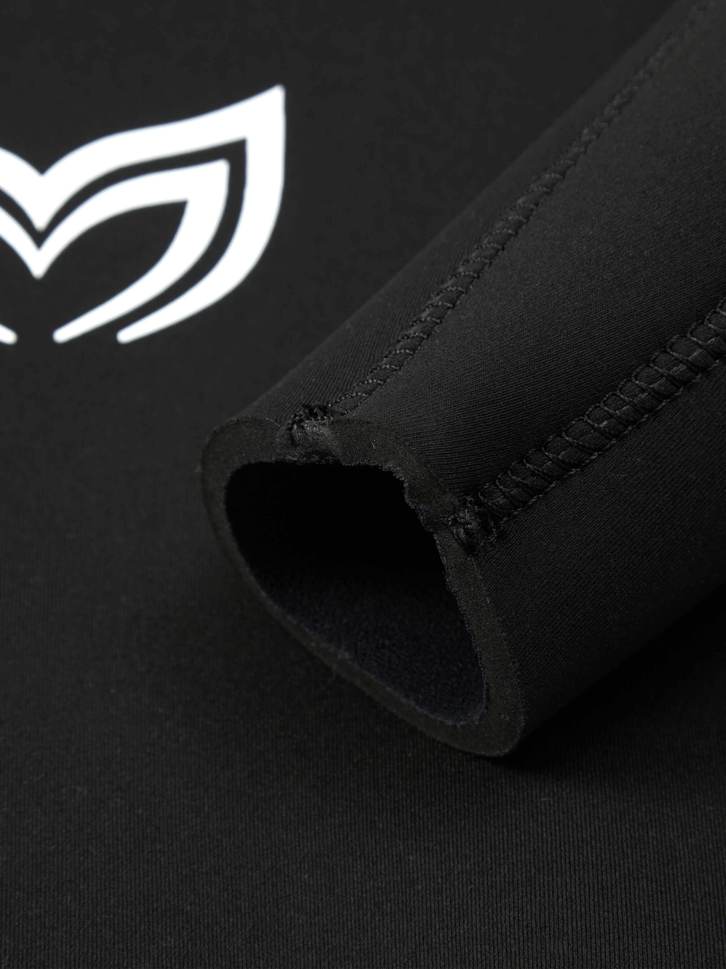 Close up of the 4.5mm black version of this womens wetsuit showing the sleeve pannels and stitching. In the background you can see the Molchanovs logo on the chest. 