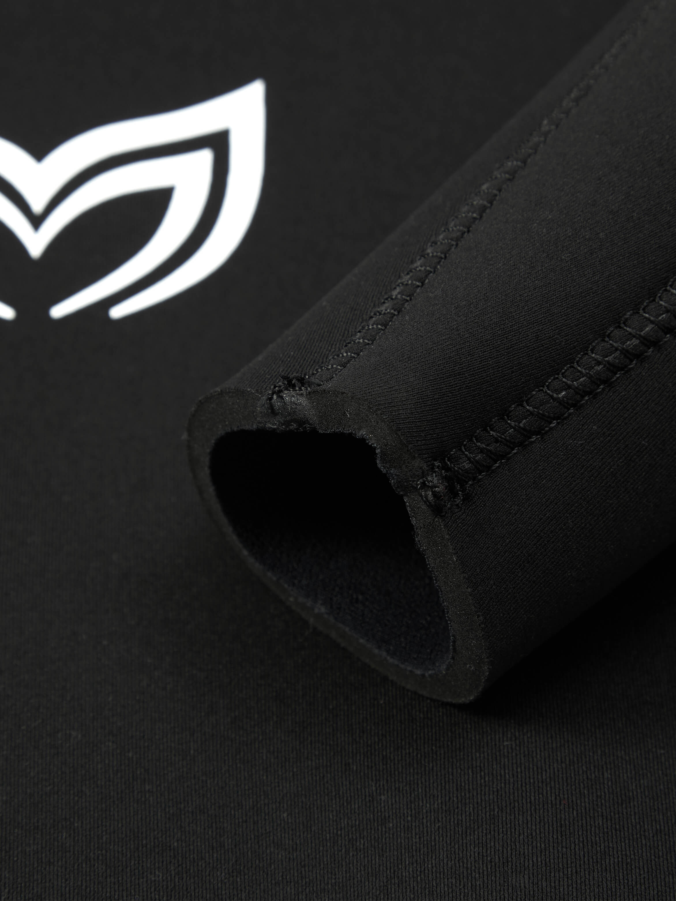 Close up of the 5mm black version of this mens wetsuit showing the sleeve pannels and stitching. In the background you can see the Molchanovs logo on the chest. 